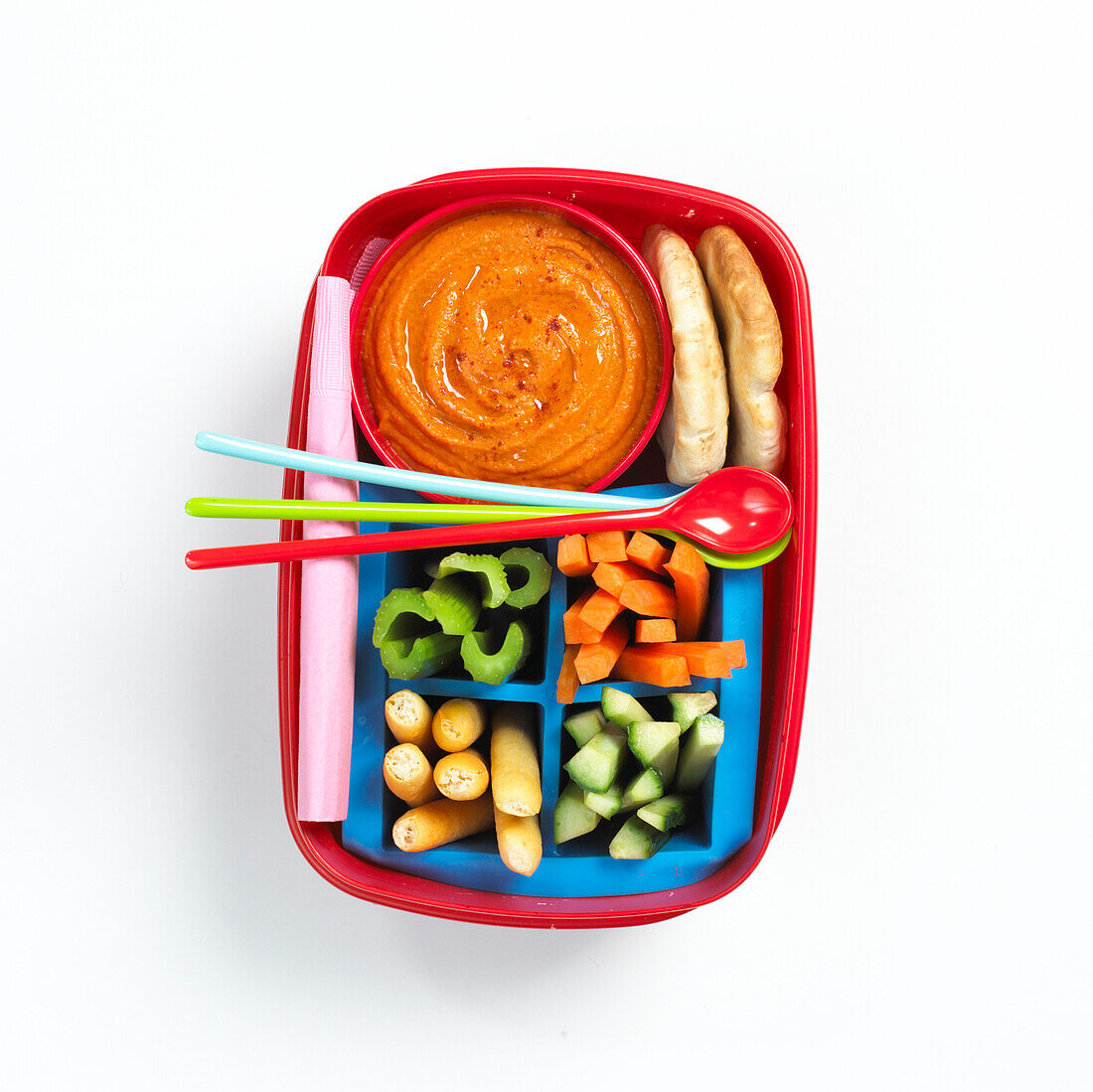Lunch box containing vegetables, dip and bread