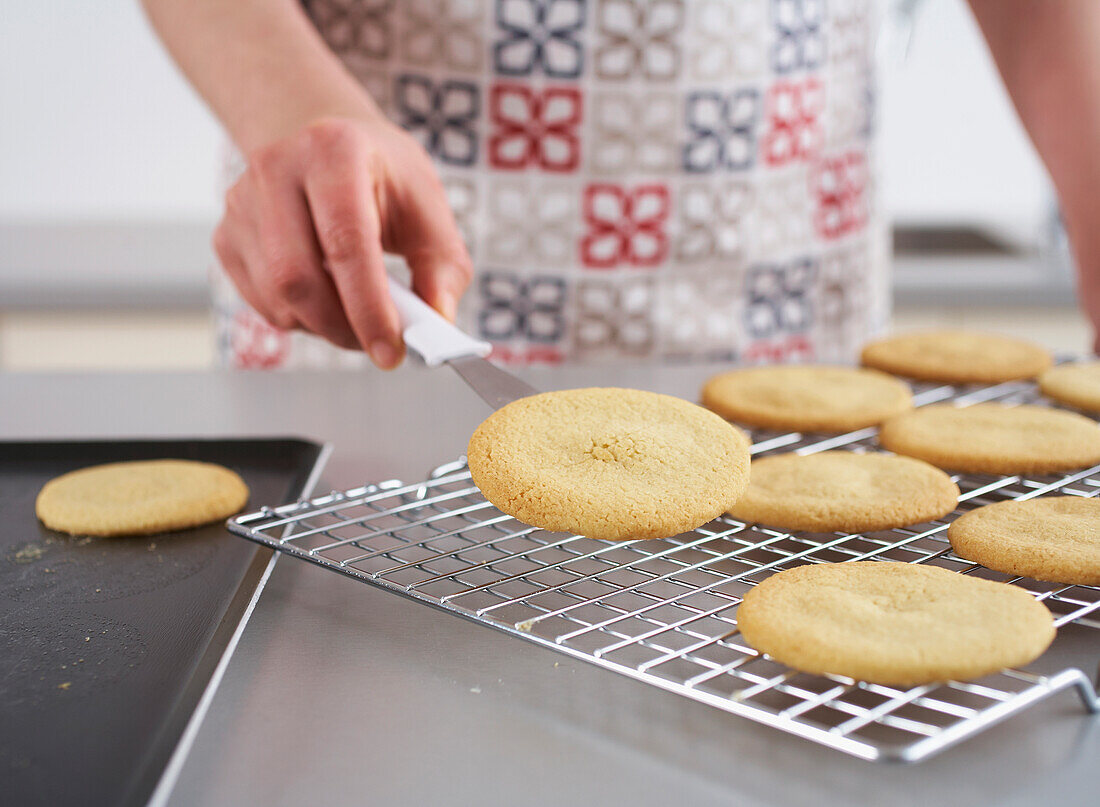 Placing round butter biscuits on cooling rack