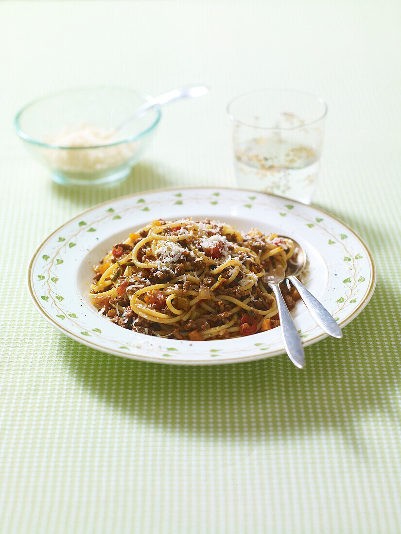 Plate of spaghetti bolognese with grated cheese on top