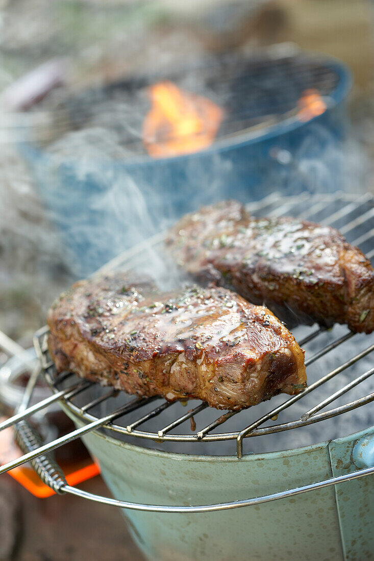 Rosemary-grilled New York strip steak on barbeque grill