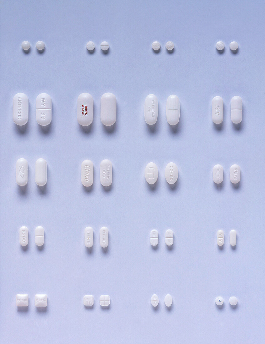 Selection of white pills and capsules arranged in pairs