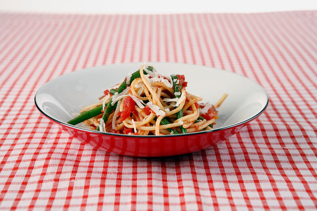 Bowl of spaghetti with green beans and tomato sauce
