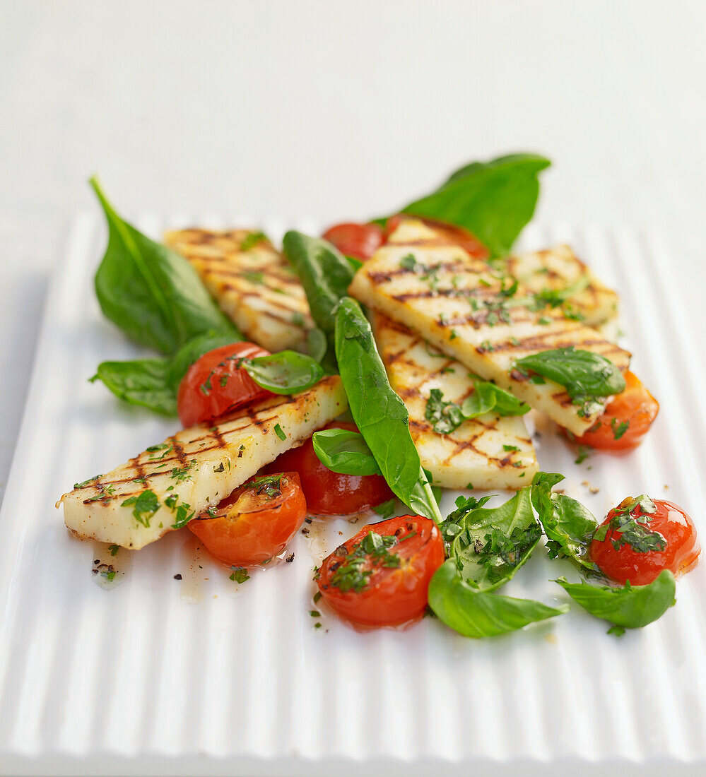 Grilled halloumi with roast tomatoes on plate
