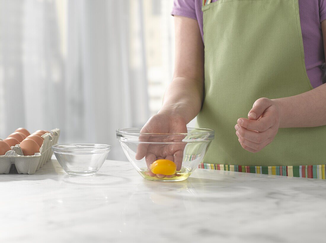 Child scooping up egg yoke in hand