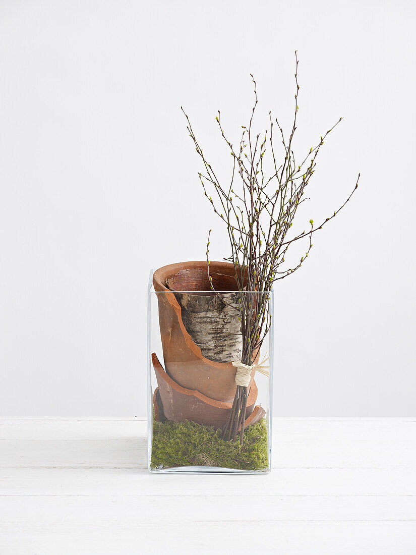 Broken terracotta pots and birch twigs in a vase