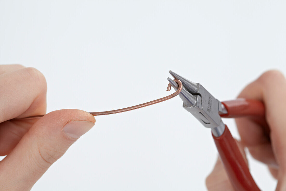 Using round-nosed pliers to make tiny loop at end of wire