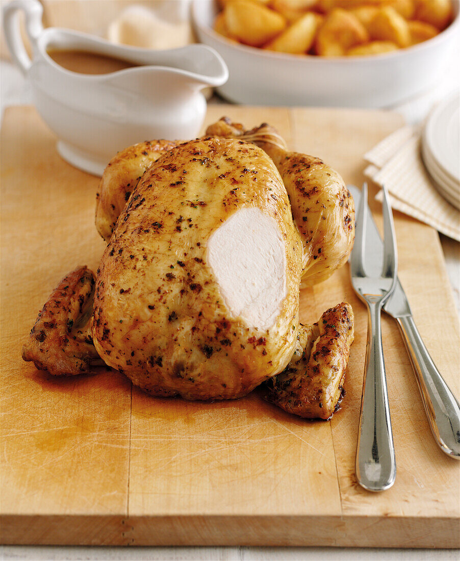 Roast chicken basted in herb butter, with a slice cut away