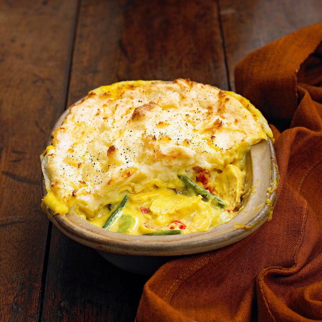 Vegetable and chicken pie topped with potato in an oven dish