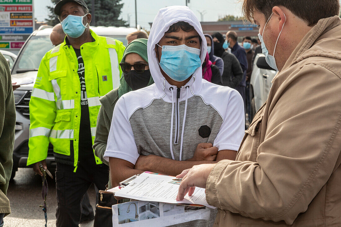 Worker checking IDs as water filters are distributed, USA