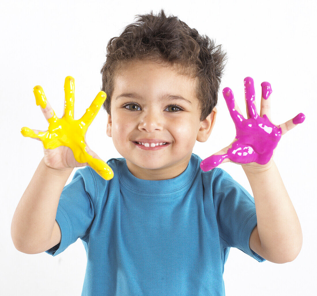 Boy with yellow and pink paint on his hands