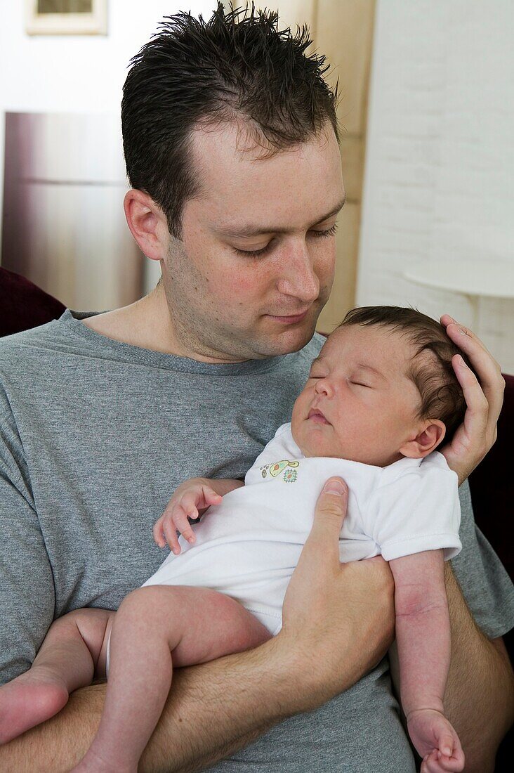Man holding sleeping baby boy in his arms