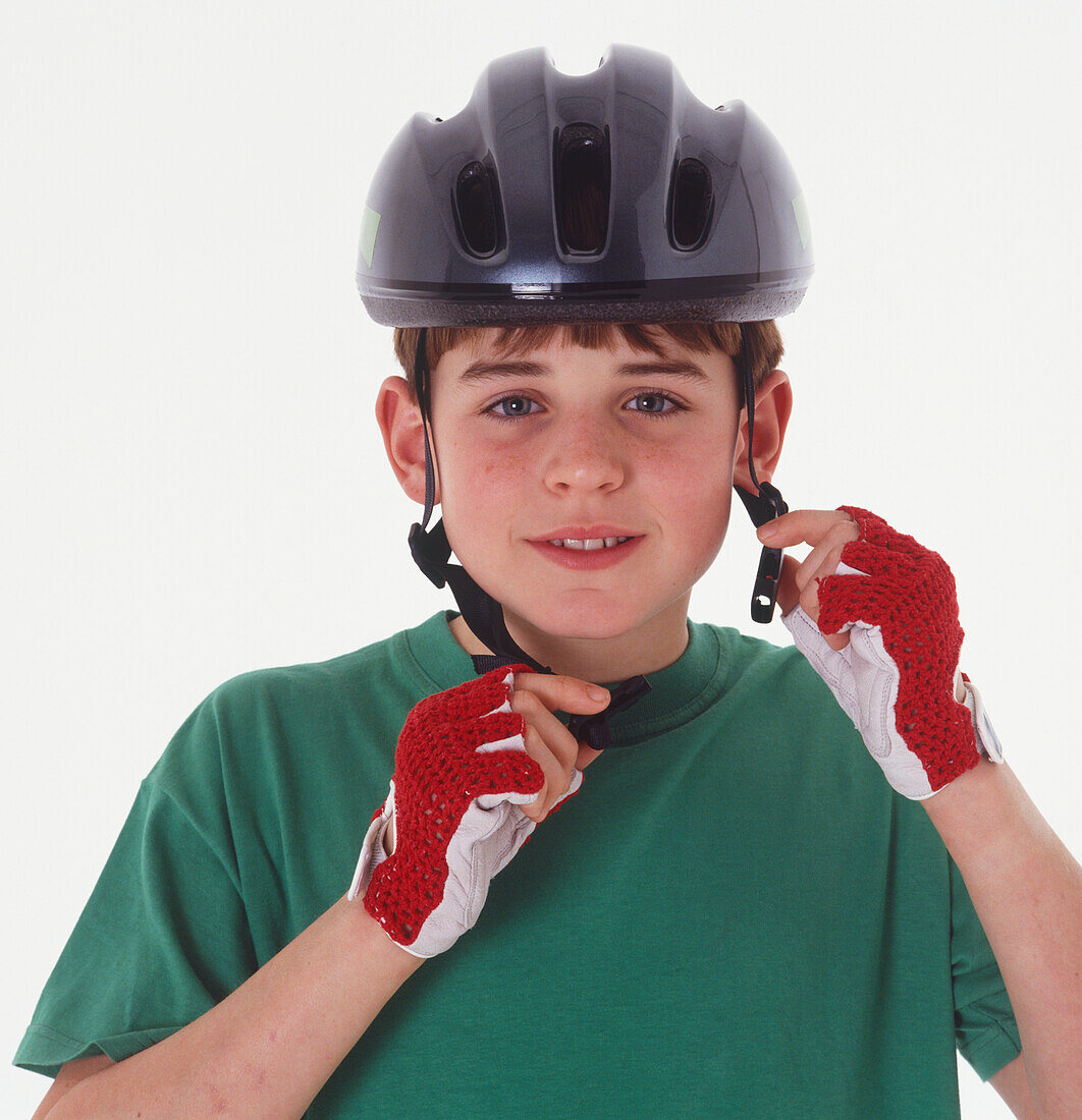Boy putting a cycle helmet on