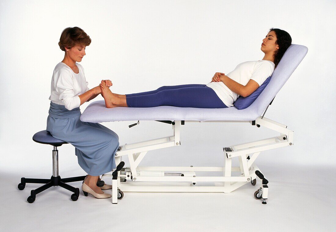 Reflexologist treating foot of a woman