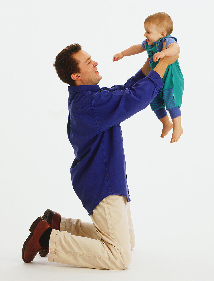 Young father lifting up his baby daughter