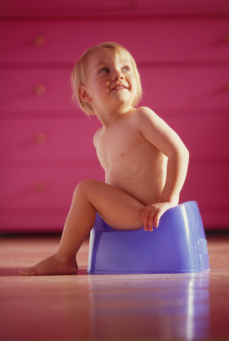 Baby sitting on a blue plastic potty