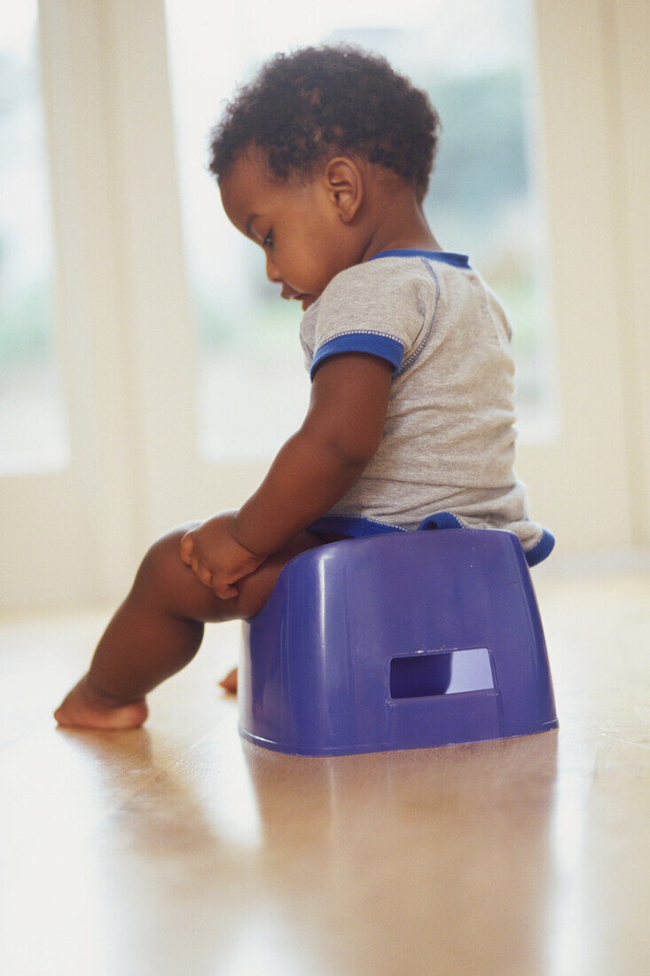 Young child sitting on blue potty