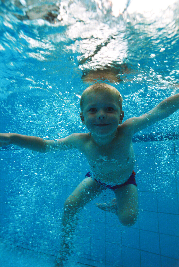 Smiling boy underwater in swimming pool