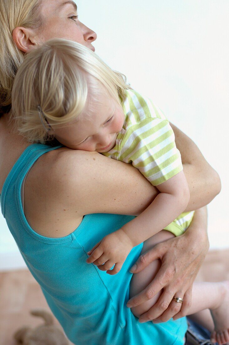 Woman holding blonde girl in arms