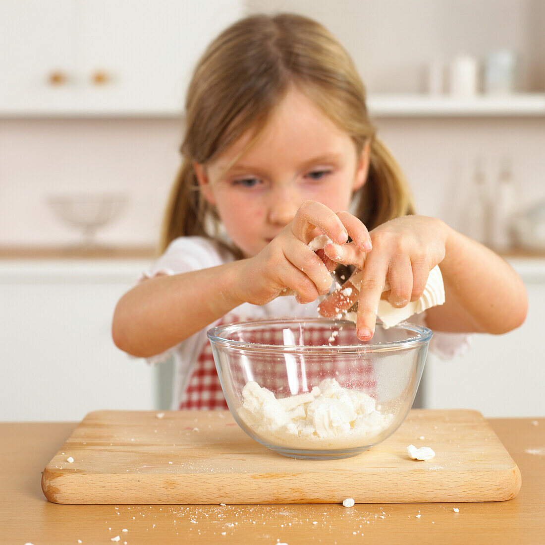 Girl cracking meringue over bowl