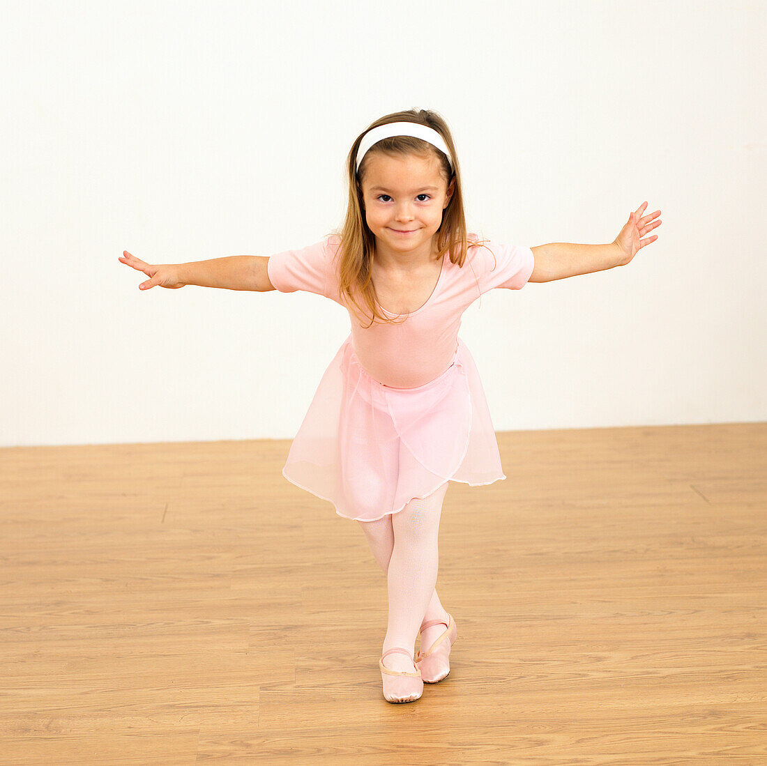 Girl in ballerina outfit with arms outstretched