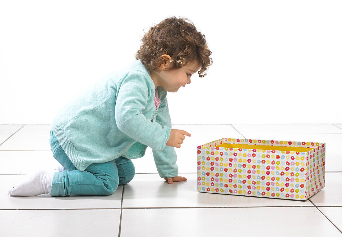 Young girl looking into colourful box