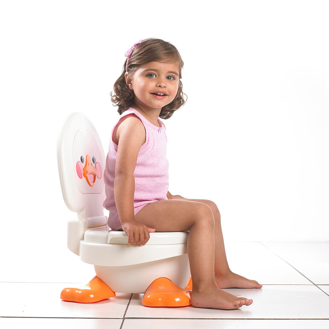 Girl wearing vest sitting on white potty