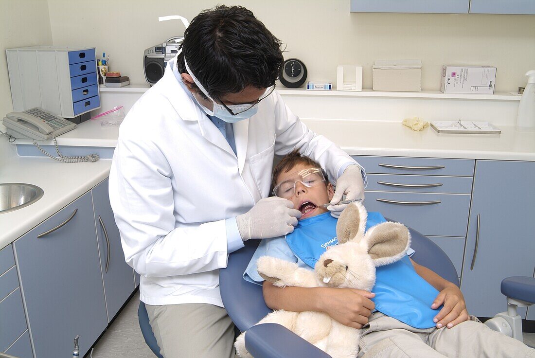 Dentist holding mirror in boy's mouth