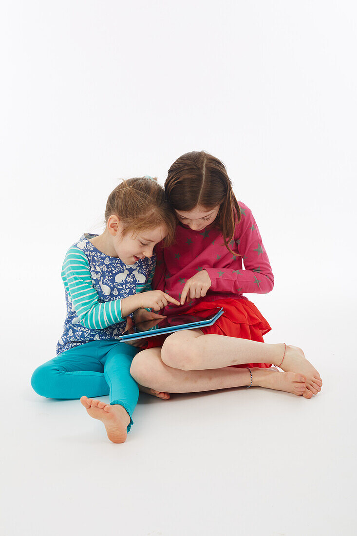 Two sisters using tablet
