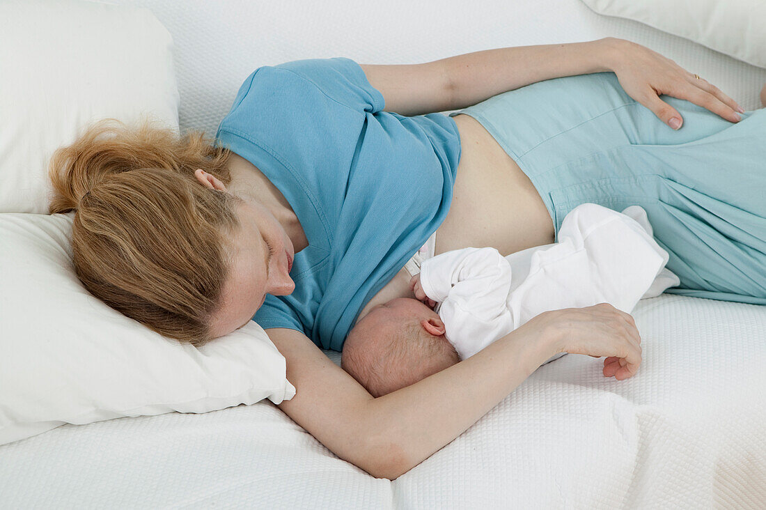 Young mother breastfeeding newborn baby boy