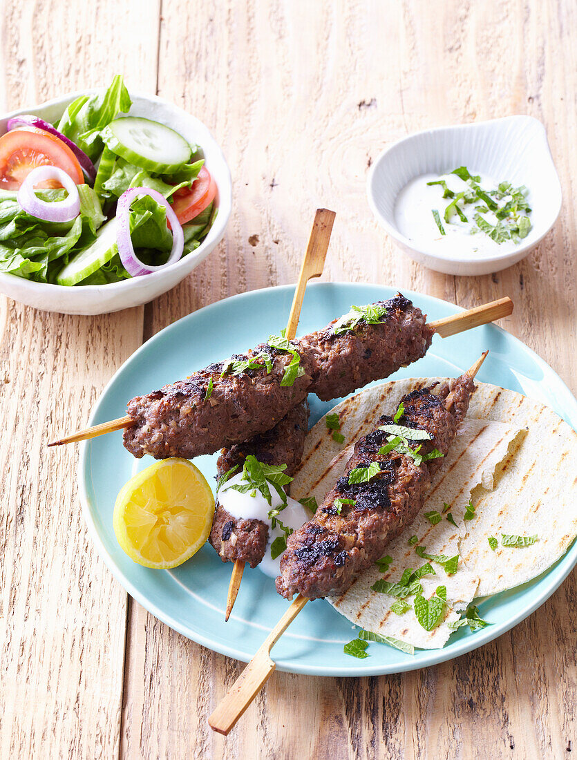 Kebab (Hackfleischspieß) mit Gemüsesalat, Fladenbrot und Joghurtdip