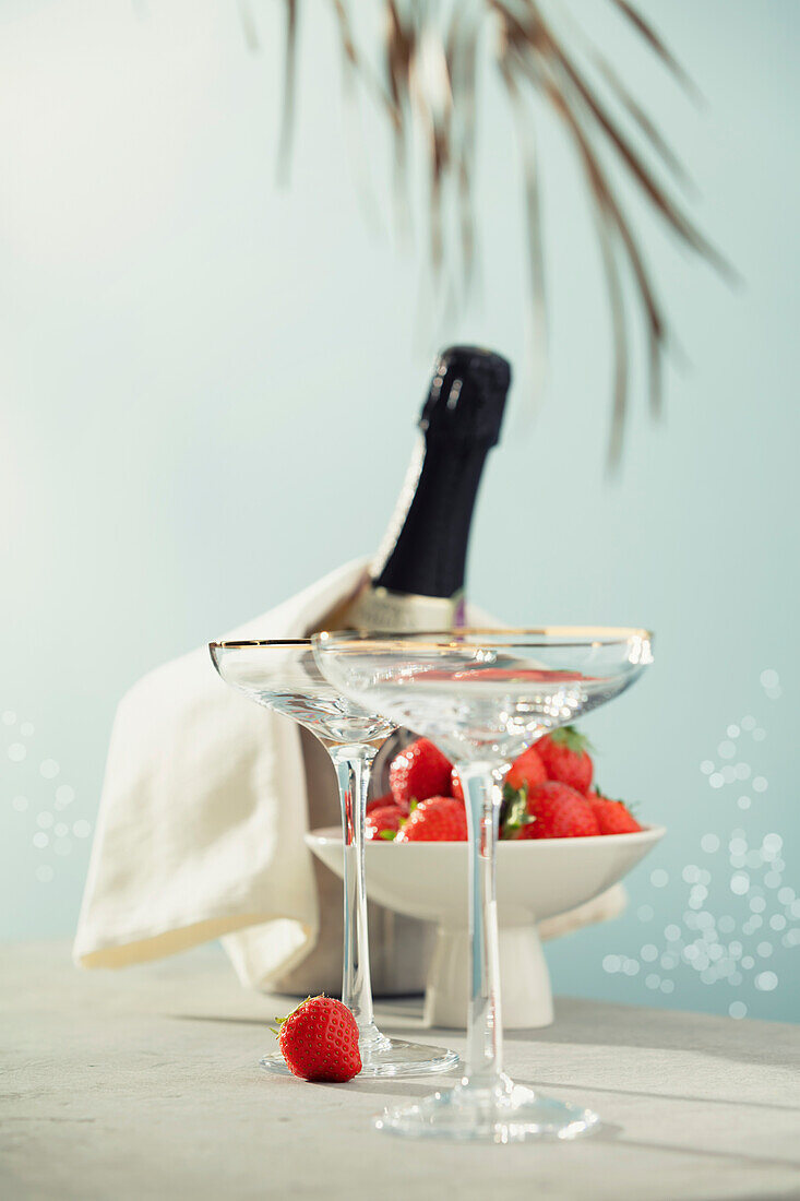 Bottle of champagne, two glasses and strawberries