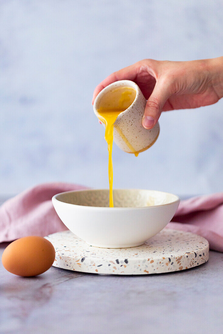 Putting beaten eggs in a bowl