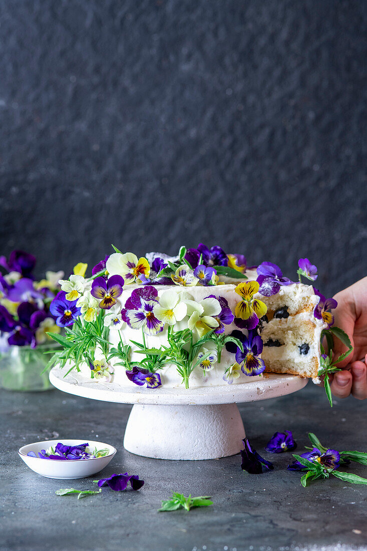 Vanilla buttercream cake with blueberries, decorated with pansies