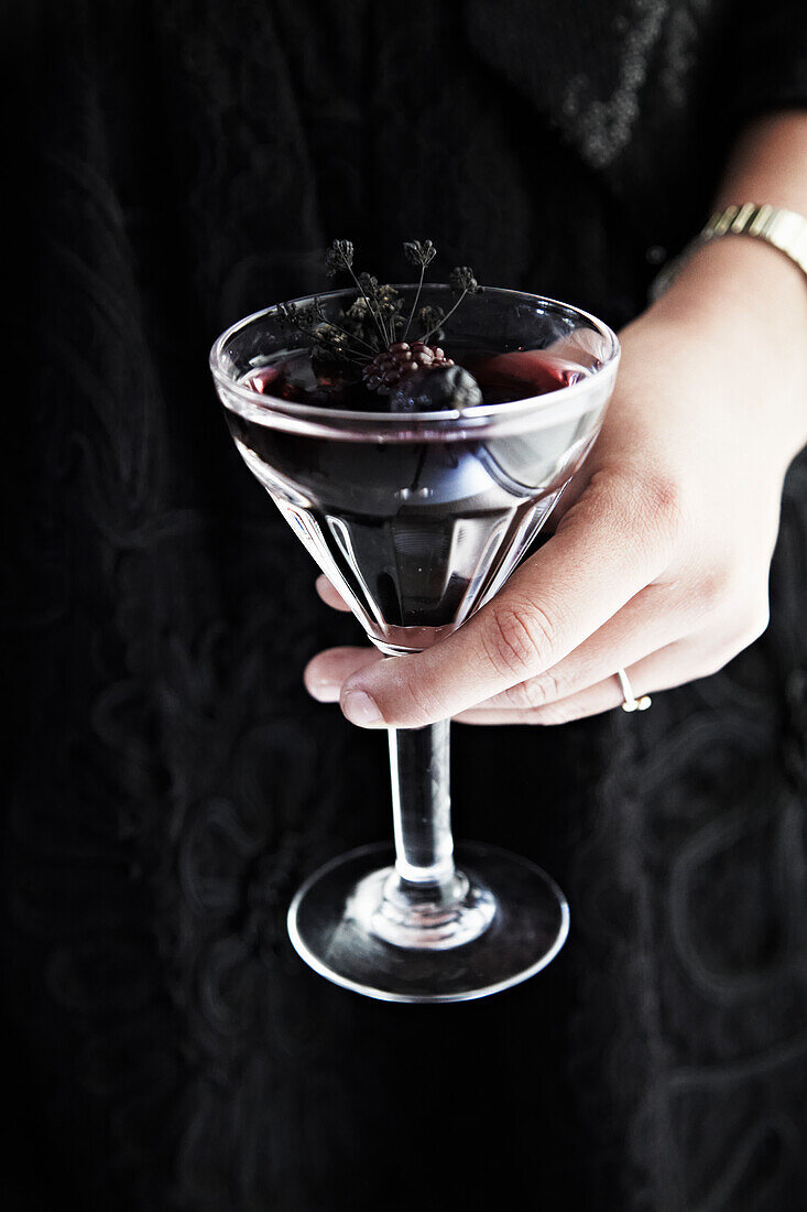 Dark cocktail with berries and thyme