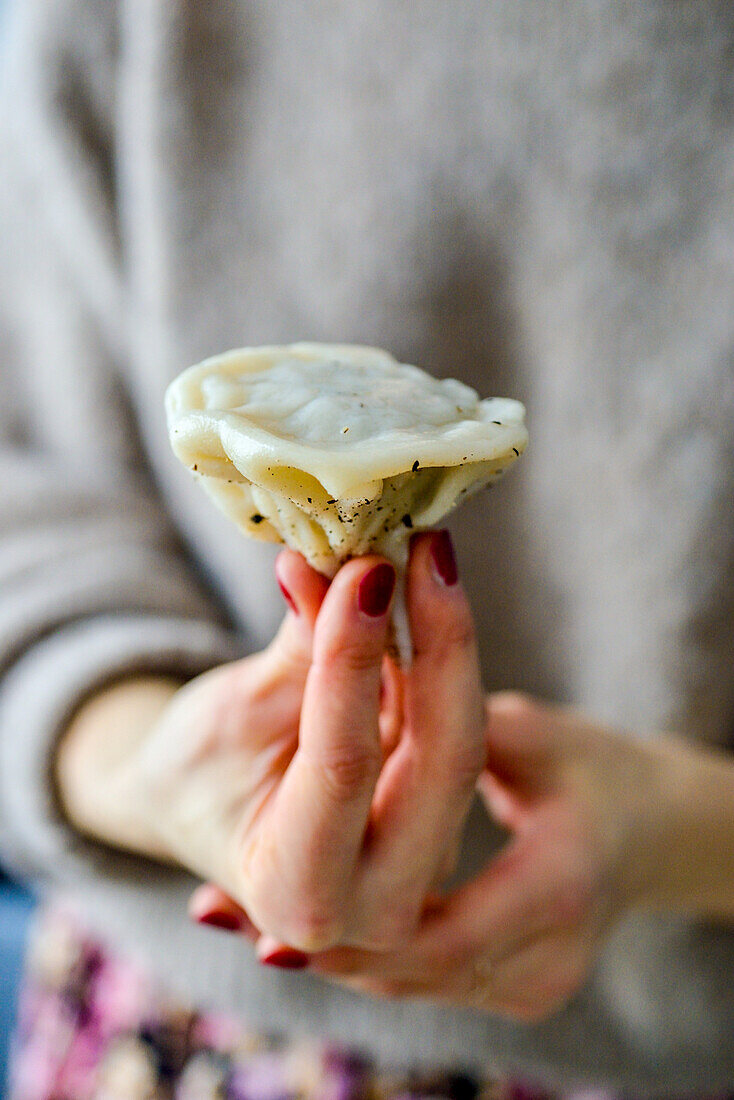 Hand holding khinkali (Georgian dumpling)
