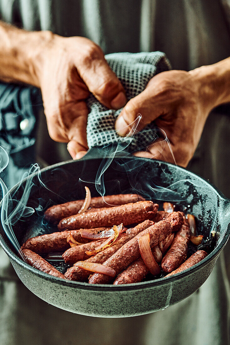 Fried sausages with onions in a pan