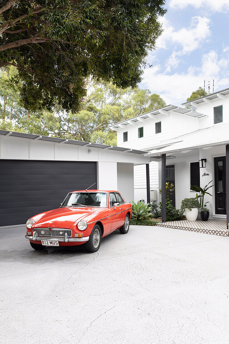 Rotes Auto vor Garage