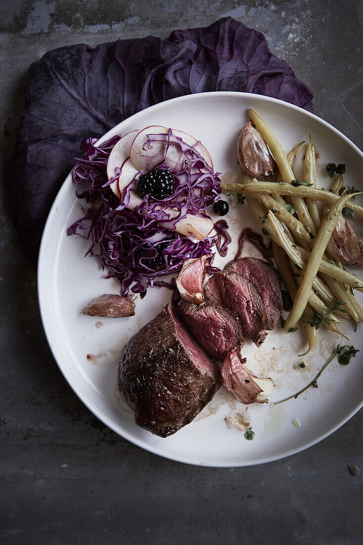 Venison steak with red cabbage salad and yellow beans