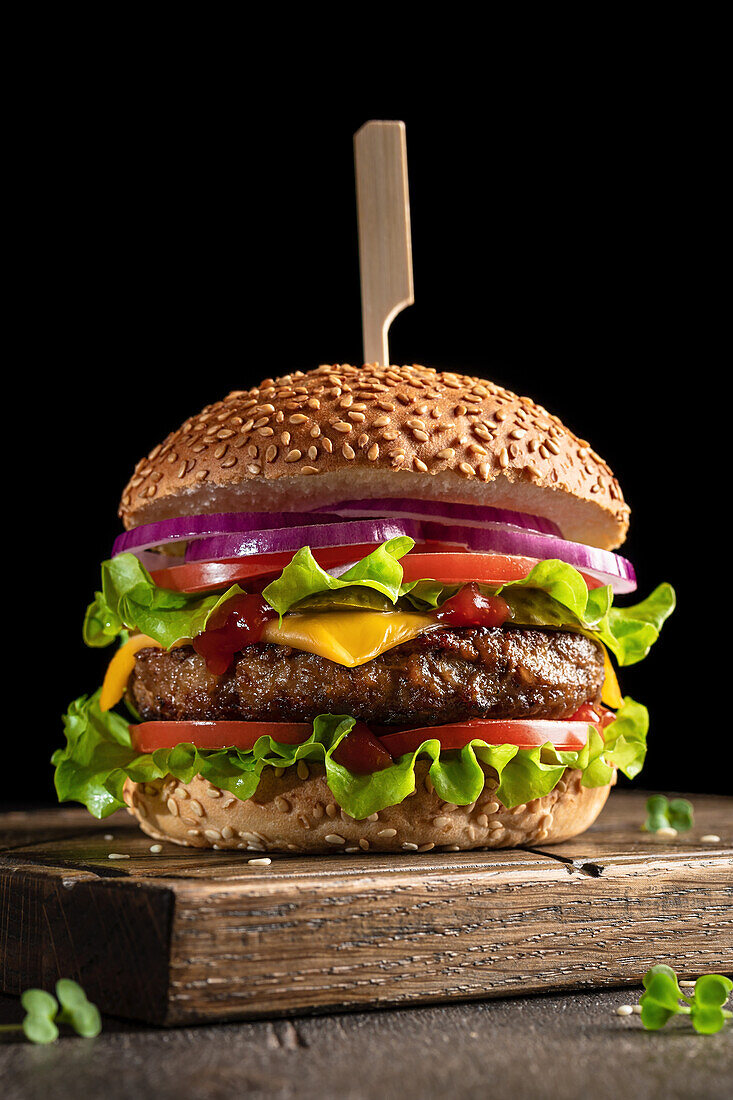 Burger mit Käse, Tomaten, roten Zwiebeln und Salat