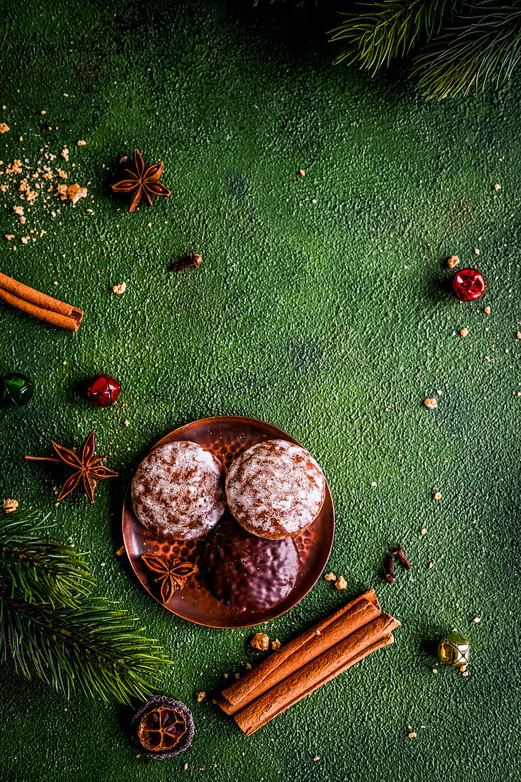 Gingerbread, Christmas spices and fir branches on a green background