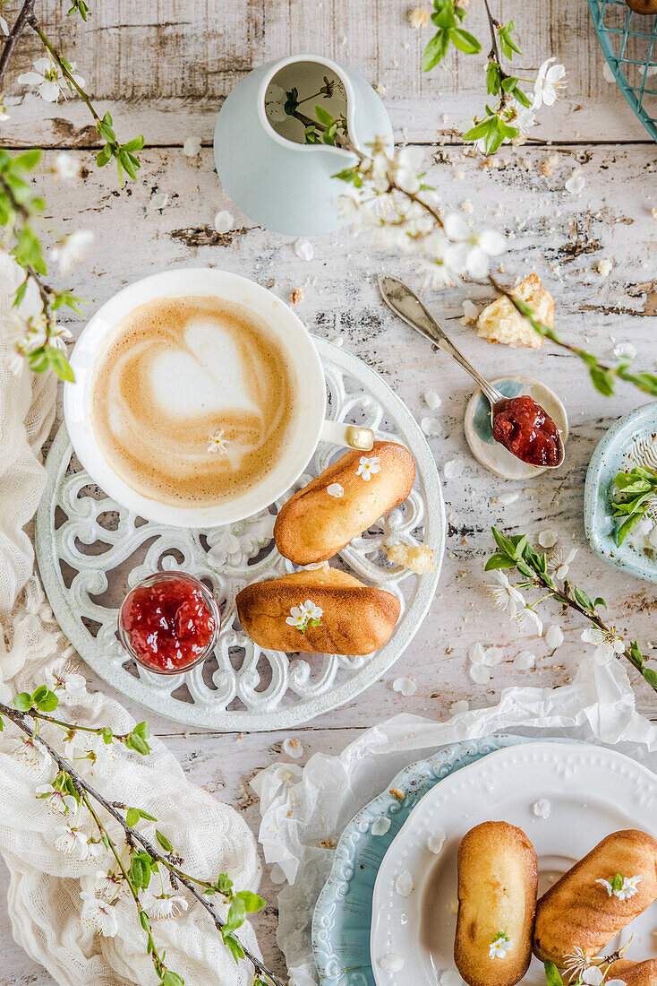 Madeleines served with a cappuccino on a spring table