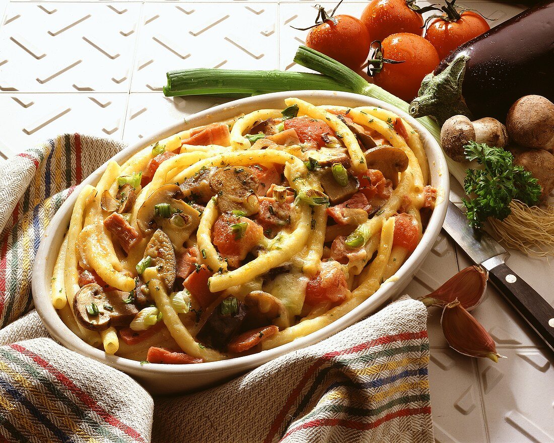 Baked macaroni with tomatoes, aubergines & mushrooms in dish