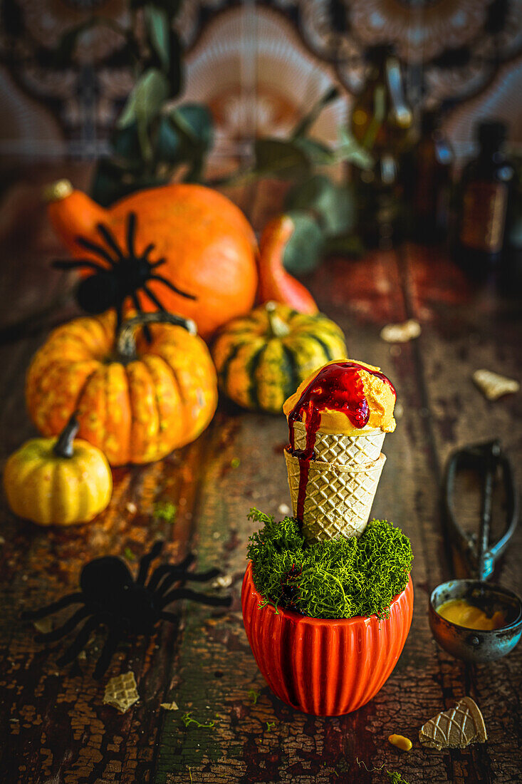 Pumpkin ice cream with raspberry syrup in a Halloween arrangement