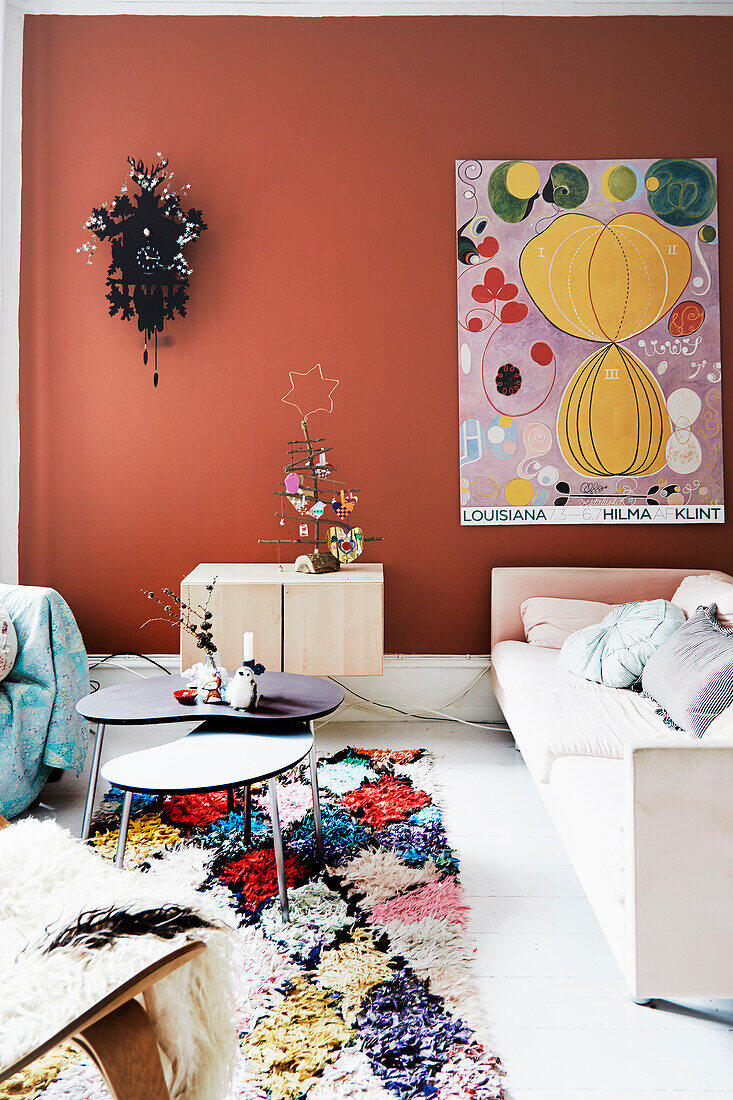 Cuckoo clock and poster on terracotta-colored wall in a living room