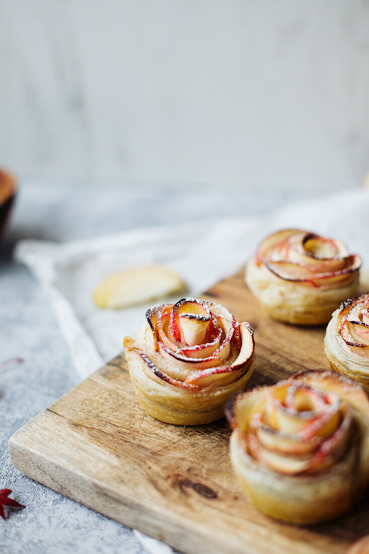 Apple rose muffins on a wooden board