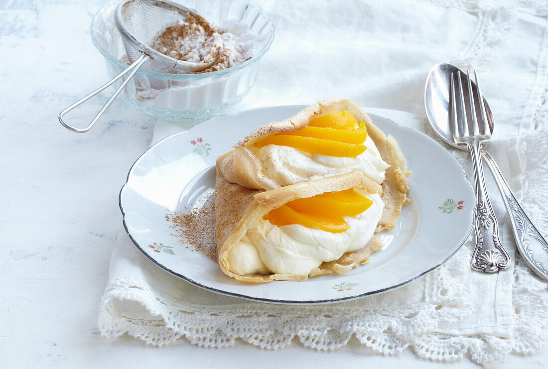 Pfannkuchen gefüllt mit Pfirsichen und Sahne