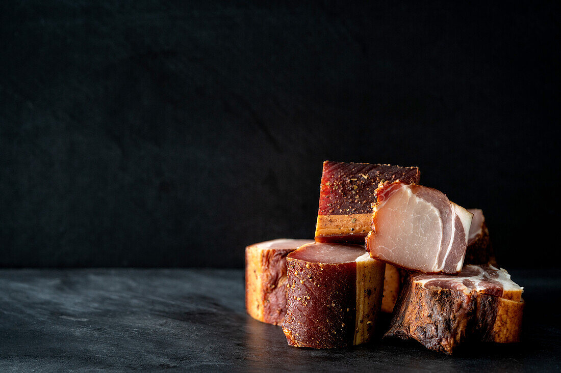 Several pieces of bacon against a dark background