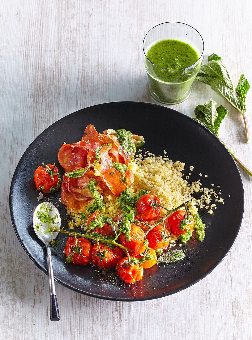 Couscous with baked tomatoes, ham, and rocket pesto