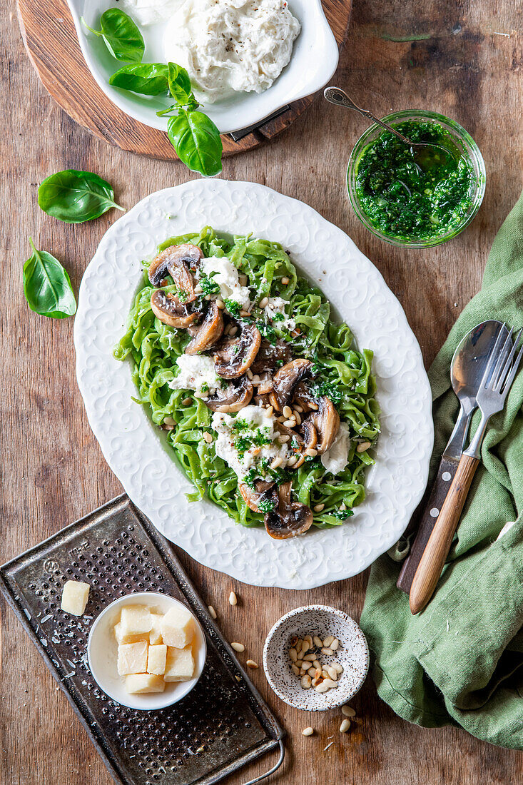 Green pasta with mushrooms and burrata