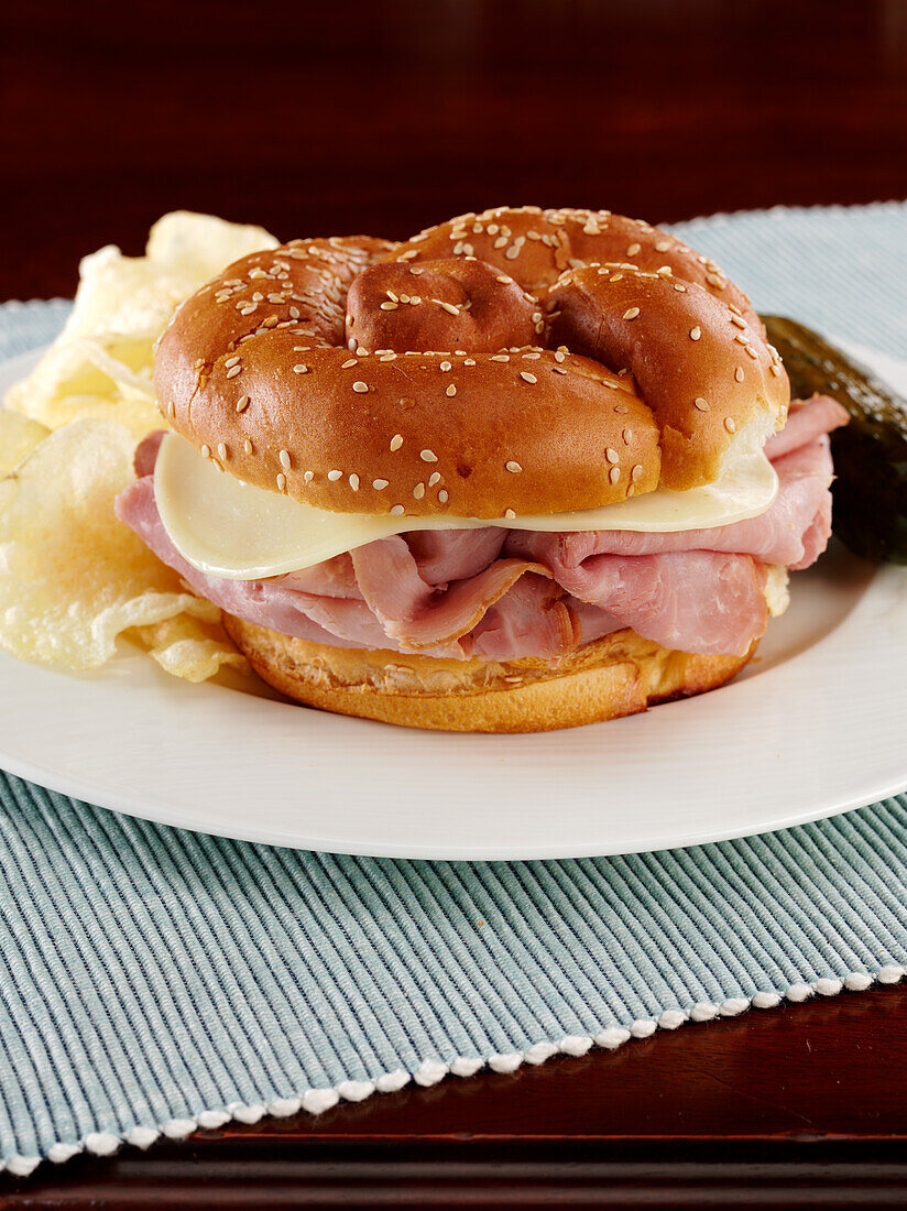 Ham and Provolone cheese on a pretzel bun with potato chips